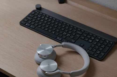 black computer keyboard beside white headphones